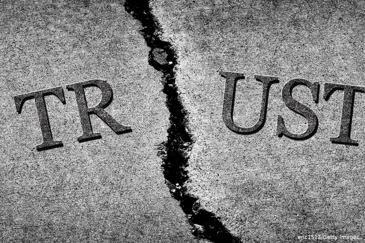 A sign reading "Trust" cracked in half