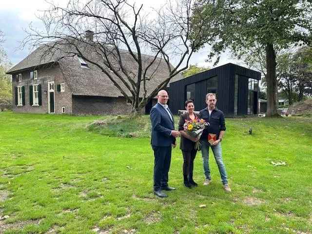 Wethouder Van Bronkhorst met de prijswinnaars. Op de achtergrond de krukboerderij met de moderne aanbouw. Foto: gemeente Wijchen