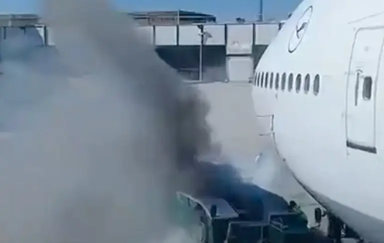 Sleepvoertuig in hens vlakbij Lufthansa Boeing 747