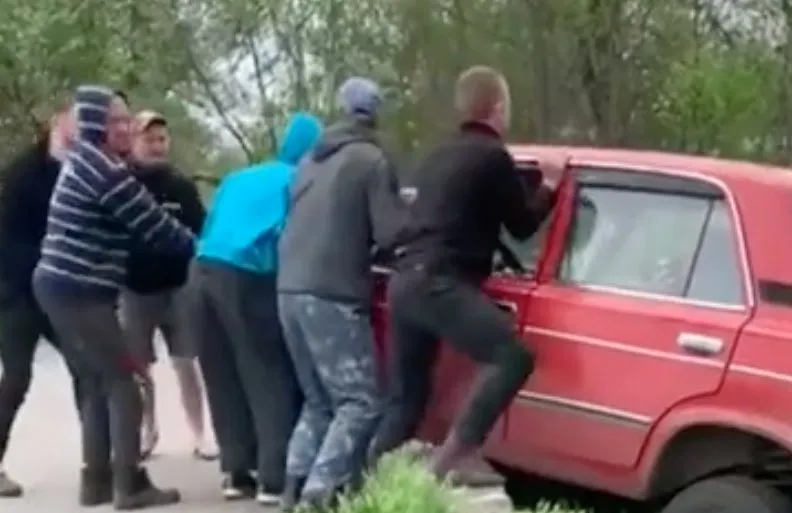 Mannen redden rode racer, rode racer duikt de greppel weer in