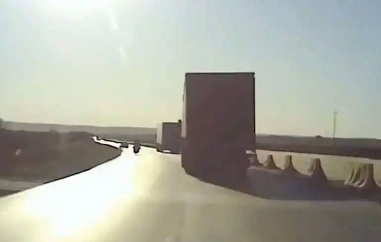 Lada krijgt volle laag van vrachtwagen na uitwijken voor motorrijder