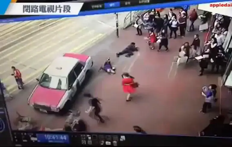 Taxichauffeur in Hong Kong is bang voor schade na omkegelen groep mensen