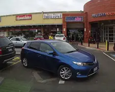 Even auto parkeren bij een winkelcentrum