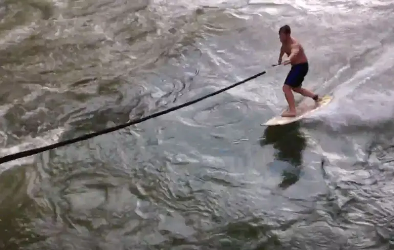 Surfer vermaakt zich prima op Zwitserse rivier
