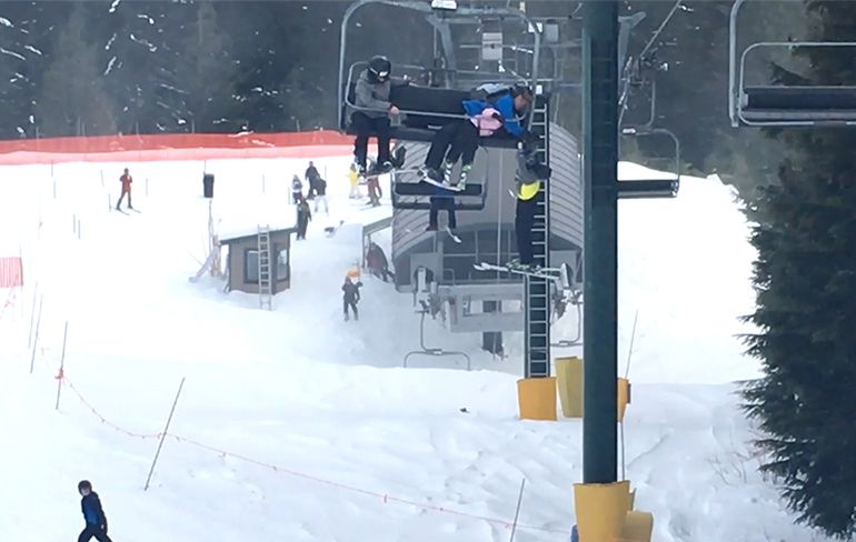 Aan skilift hangend jongetje opgevangen door mensen op de grond