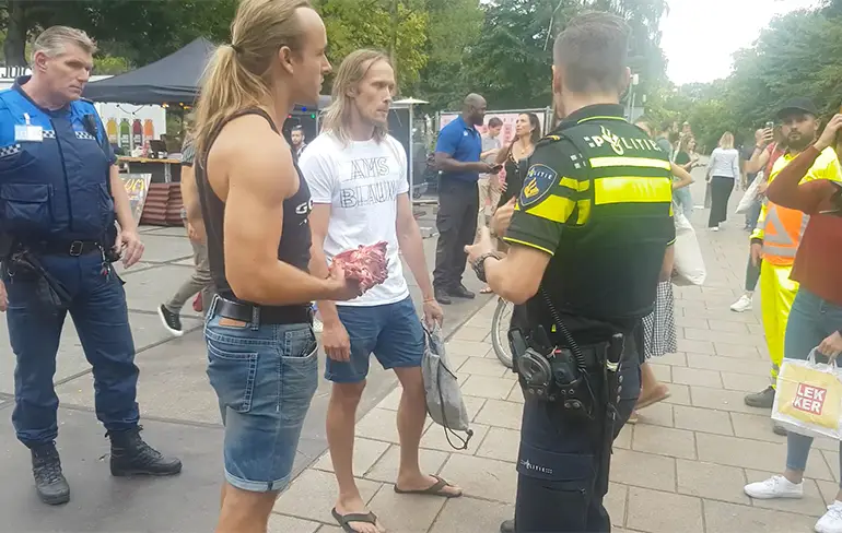 Activist eet even lekker rauw stukje vlees bij ingang Vegan Food Festival