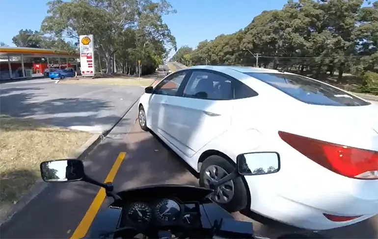 Auto in Australië slaat af, motorrijder rijdt tegen auto...