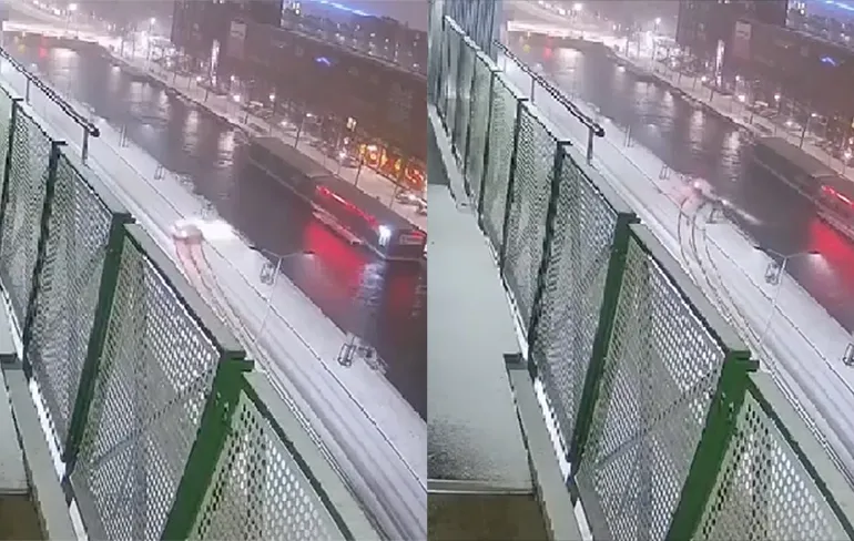 Automobilist slipt door gladheid zo het water in op Neherkade in Den Haag