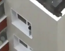 Baby India speelt in raam flatgebouw