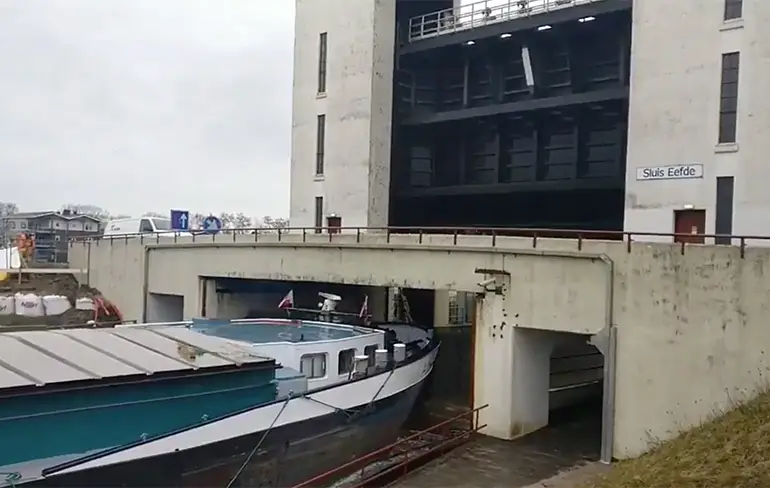 Binnenvaartschip kan maar net onder brug door