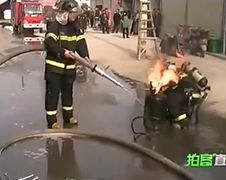 Chinese brandweerman draagt brandende gasfles naar buiten