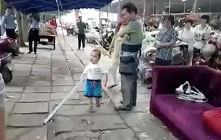 Chinese kleuter wil oma helpen met stalen pijp