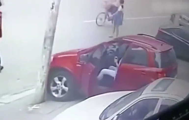 Chinese vrouw denkt superkracht te hebben en wil rollende auto stoppen...