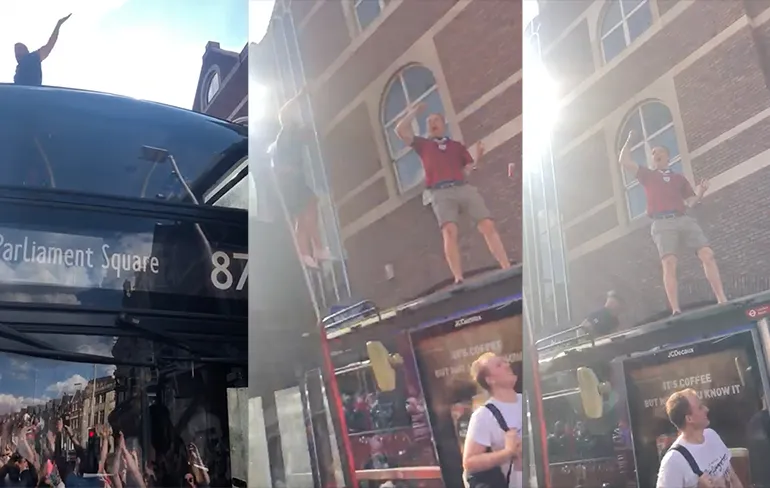 Engelse fan die door bushokje pleurt van andere kant