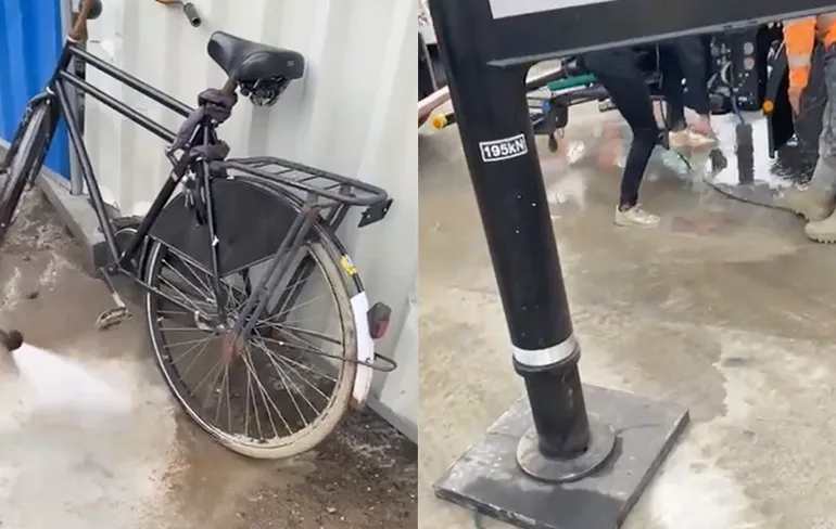 Fietser in Amsterdam rijdt door nat beton