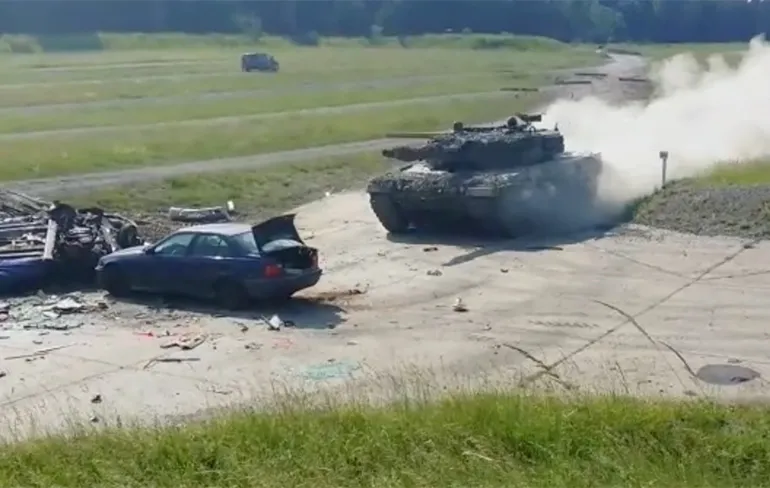 Geparkeerde auto verliest van rijdende tank