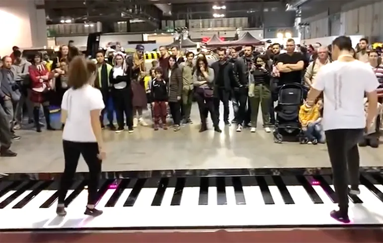 Het nummer "He's a Pirate" op een grote piano op de grond