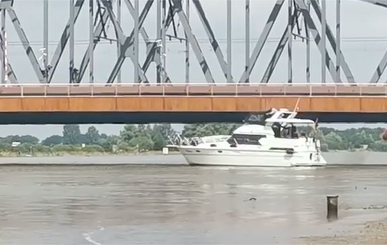 Kapitein bootje onderschat hoge waterstand en knalt tegen Oude IJsselbrug aan