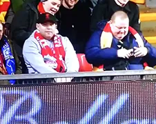 Liverpool fan ziet Gabby Agbonlahor over de boarding vallen...