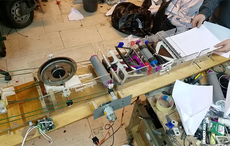 Machine om papieren vliegtuigjes te vouwen en te lanceren