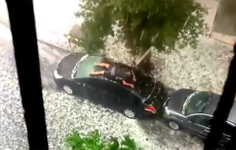 Man probeert zijn auto te beschermen tegen fikse hagelbui!