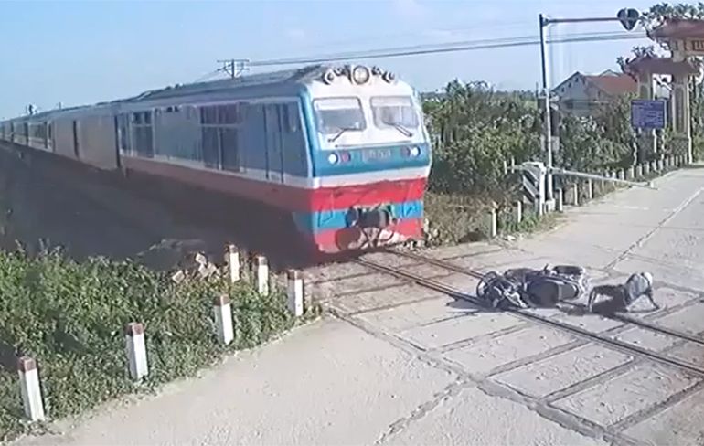 Motorrijder in Vietnam ontsnapt aan gewisse dood door naderende trein