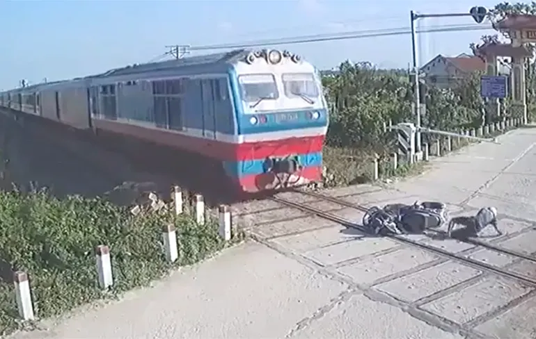 Motorrijder in Vietnam ontsnapt aan gewisse dood door naderende trein