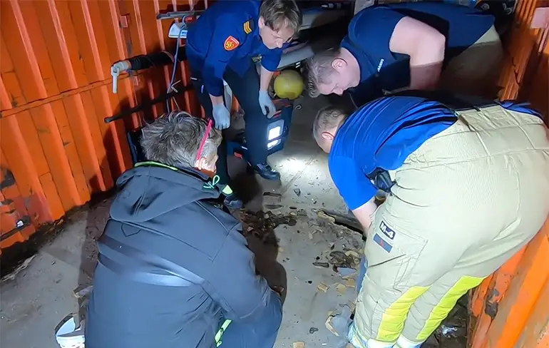 Nederlandse brandweermannen redden hond die vast zat onder container