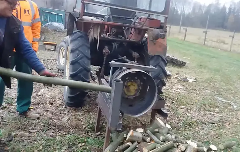 Polen maken brandhout met behulp van een tractor
