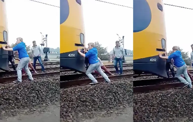 Reizigers proberen kapotte trein verder te duwen
