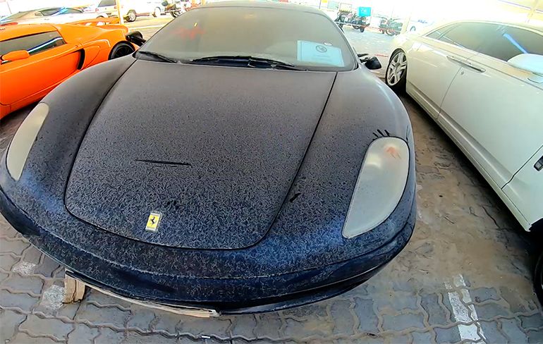 Rondwandelen op een opslagplaats met verlaten supercars in Dubai