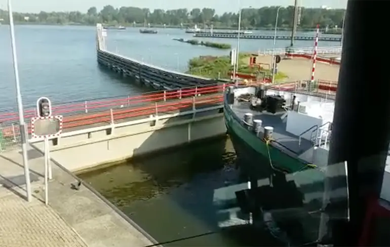 Schipper gebruikt deur als rem in Oranjesluizen in Amsterdam