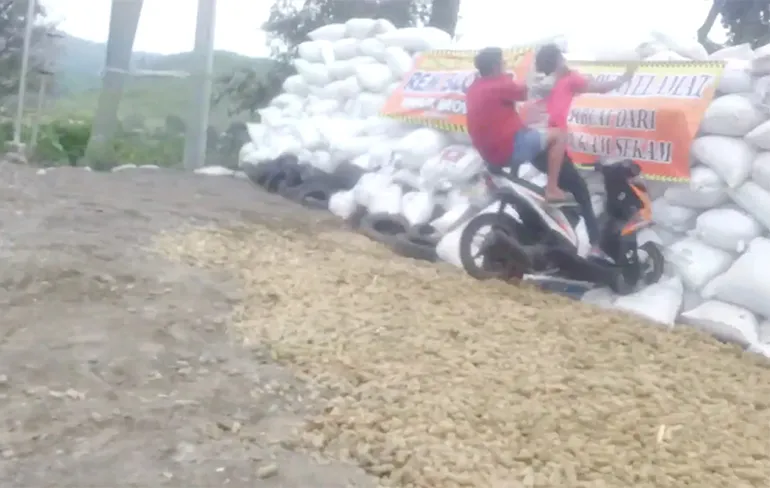 Scooterrijder op Indonesische eiland Java mist een bochtje
