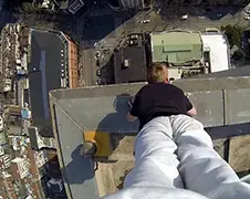 Scott Young doet handstand op hoog gebouw in Shanghai