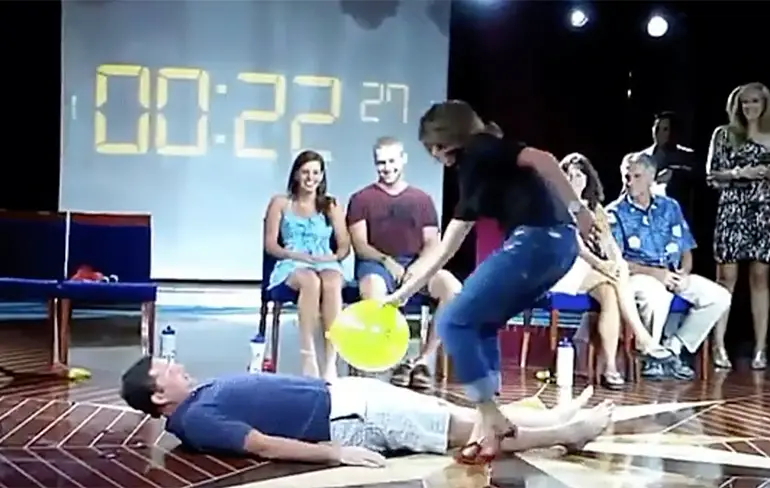 Spelletje ballonnen kapot maken is pijnlijk met partner op hakken