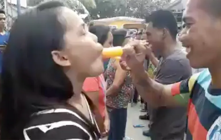 Spelletje op de De Filipijnen: Wie zuigt het snelst een ijsje op...