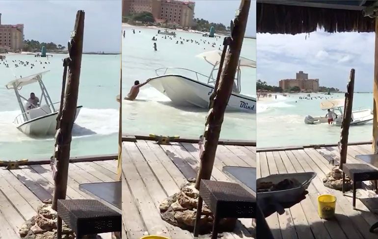 Van de pier genieten van bootje in problemen op Aruba