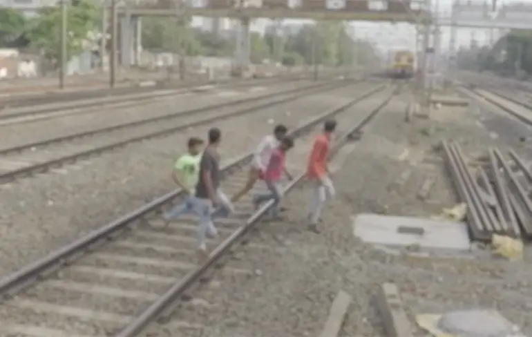 Vrienden redden man die vastzit met voet tussen treinrails