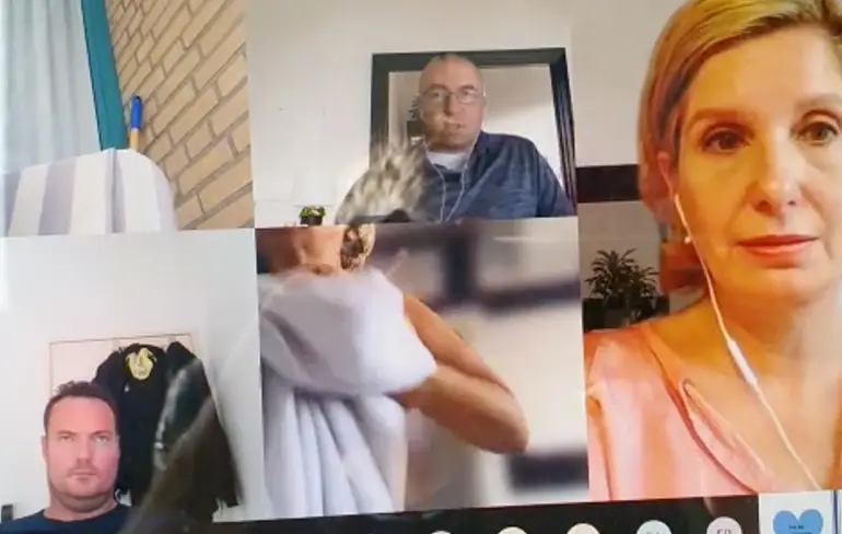 Vrouw kleedt zich rustig aan tijdens online vergadering, niemand zegt iets