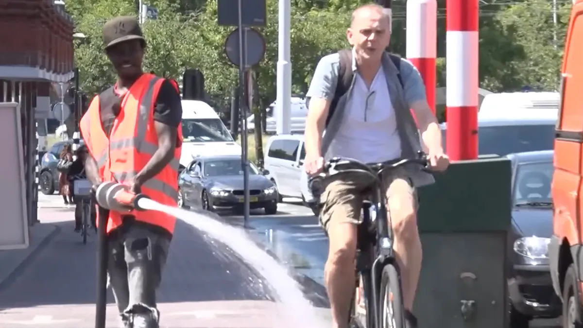 Man die brug nat spuit in Amsterdam heeft plezier in zijn werk