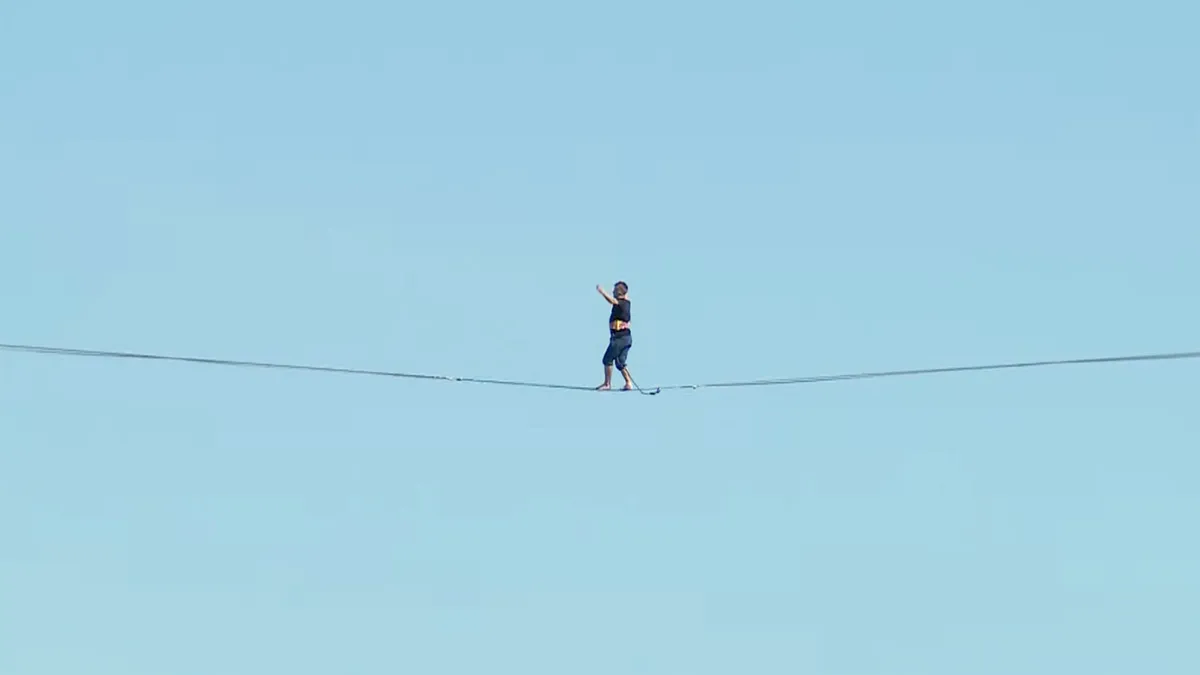 Koorddanser Jaan Roose gaat over de Maas van de Rotterdam naar de Zalmhaventoren lopen