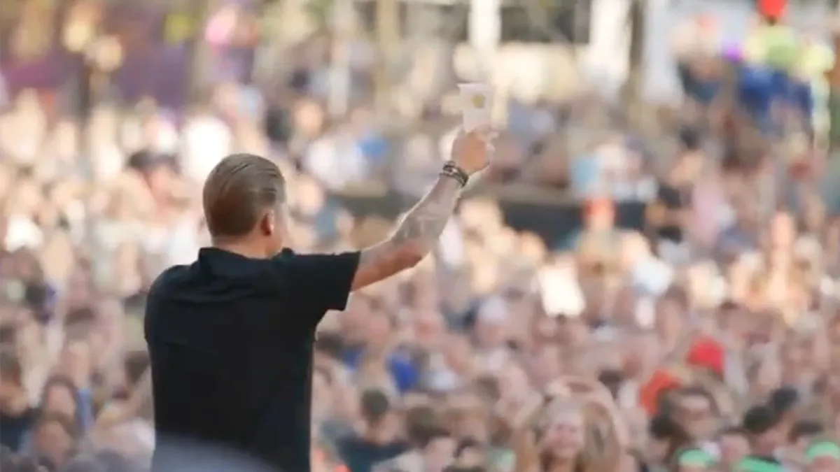 Weer bier gegooid naar Mart Hoogkamer, maar hij vangt biertje en zingt door