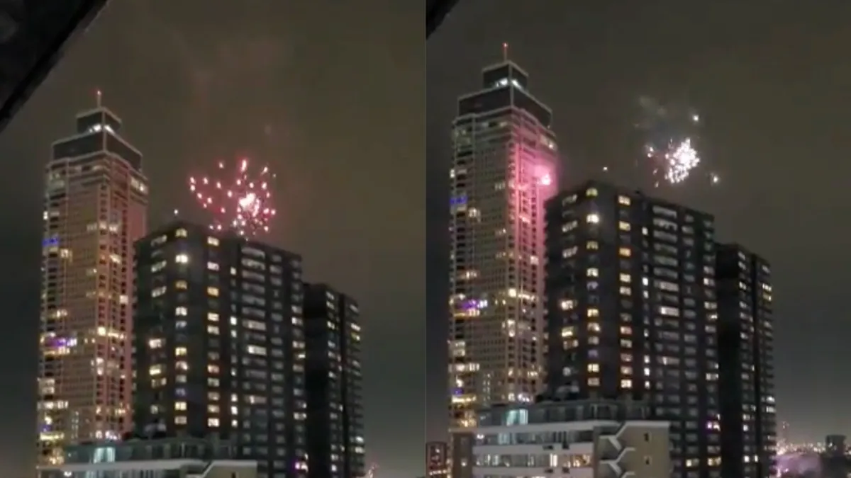 Iemand steekt vuurwerk af van de Rotterdamse Zalmhaventoren