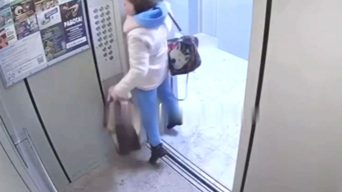 Vrouw heeft riem van hond om middel gebonden en dat is spannend in een lift