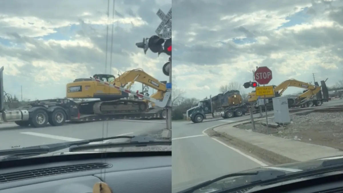 Vrachtwagen met graafmachine als lading geramd op spoorwegovergang door trein