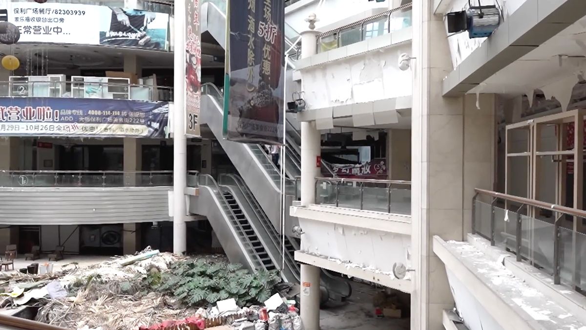 Beveiliger kijkt rustig naar natuurfilm terwijl Urban Explorers verlaten winkelcentrum bekijken