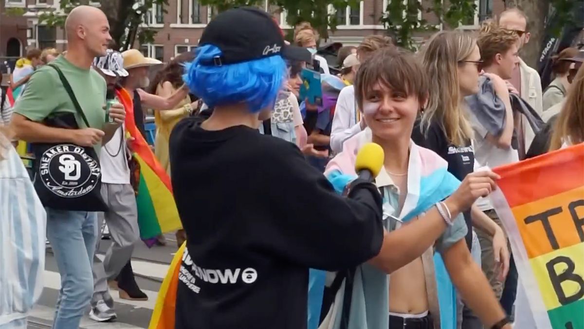 Jonge journalist Bender stelt vragen bij een pride walk in Amsterdam