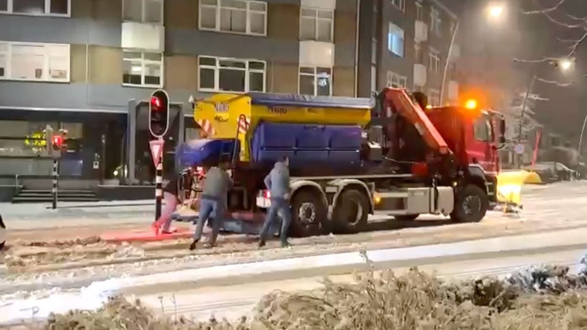 Cafégangers helpen strooiwagen weer op weg die vastzit in de sneeuw