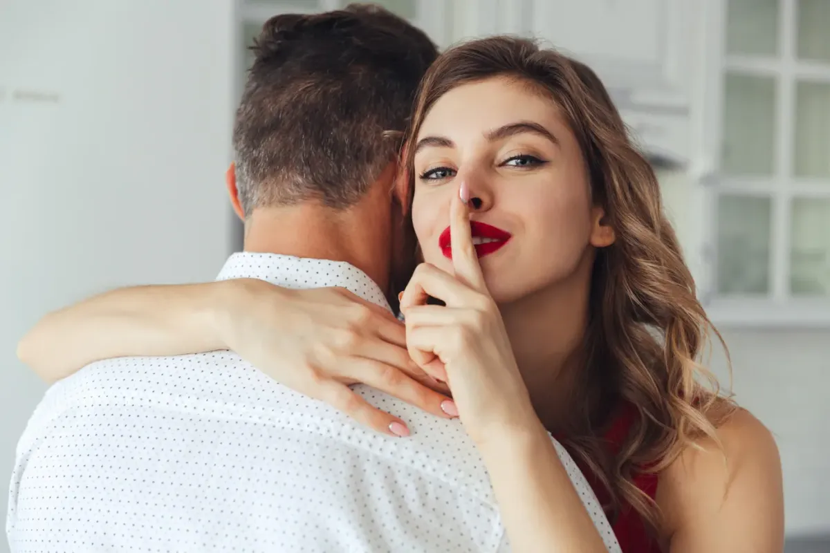 young woman making silence gesture while hug her husband 171337 501