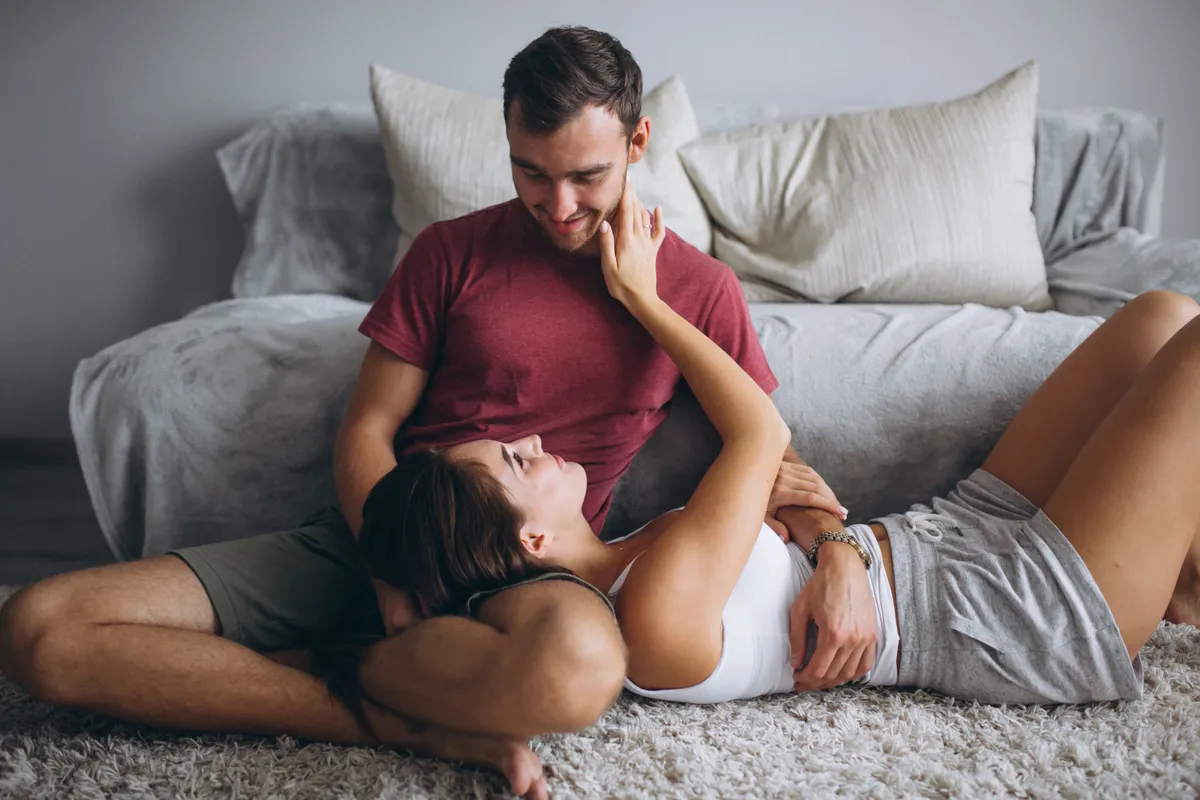 portrait couple home together sitting floor by couch
